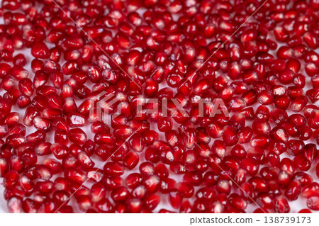 Crimson seed embellishment. Decorative garnishing idea with luminous crimson pomegranate seeds. Vivid display of scattered pomegranate seeds creating joyful holiday atmosphere Crimson seed embellishment. Decorative garnishing idea with luminous crimson pomegranate seeds. Vivid display of scattered pomegranate seeds creating joyful holiday atmosphere 138739173
