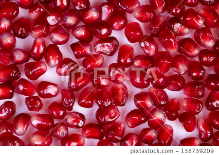 Bright pomegranate seeds evoke festive holiday mood, rich red tones, sparkling highlights, perfect for seasonal banners, party invitations, and celebration visuals 138739209