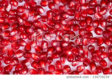 Repetitive textured presentation of pomegranate seeds for different dishes. Strategic placement of arils creating appealing visuals for packaging and culinary purposes Repetitive textured presentation of pomegranate seeds for different dishes. Strategic placement of arils creating appealing visuals for packaging and culinary purposes 138739234
