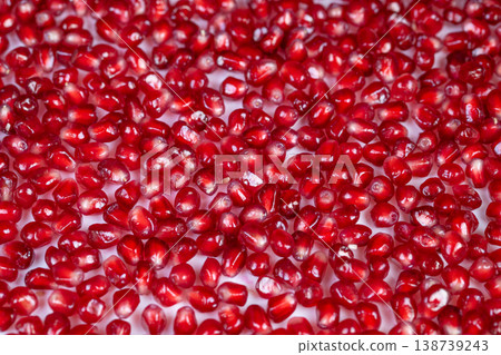 Vivid seed mosaic. Bright red pomegranate seeds forming decorative mosaic background. Vibrant and glossy seed arrangement producing artistic and textured visual display Vivid seed mosaic. Bright red pomegranate seeds forming decorative mosaic background. Vibrant and glossy seed arrangement producing artistic and textured visual display 138739243