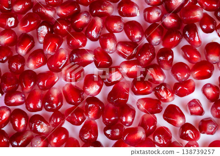 Highcontrast studio shot emphasizing illuminated reddish fruit interiors. Macro image capturing translucent pomegranate seeds with reflective gloss and vibrant coloration Highcontrast studio shot emphasizing illuminated reddish fruit interiors. Macro image capturing translucent pomegranate seeds with reflective gloss and vibrant coloration 138739257