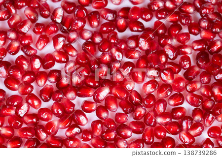 Glistening pomegranate seeds. Bright studio lighting emphasizes seed texture and color. Food stylist meticulously arranges shiny pomegranate seeds for appealing and fresh display Glistening pomegranate seeds. Bright studio lighting emphasizes seed texture and color. Food stylist meticulously arranges shiny pomegranate seeds for appealing and fresh display 138739286