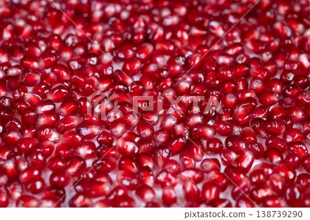 Juicy crimson clusters. Rustic bowl filled with vibrant red arils. Colorful pomegranate seeds arranged in traditional bowl evoke essence of farmfresh produce and nourishment 138739290