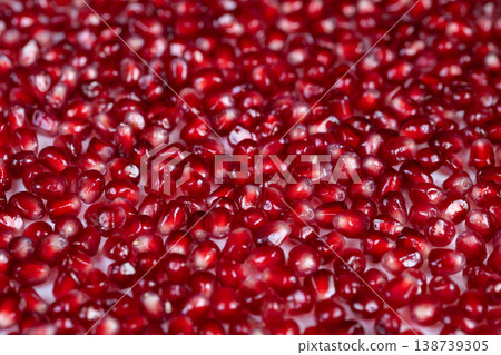 Reflective crimson seeds on clean white background. Closeup of glossy ruby pomegranate seeds on pristine white surface showcasing translucency and luscious texture 138739305