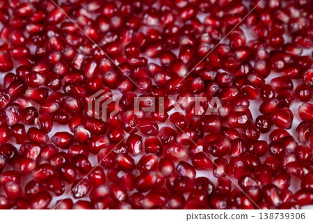 Rich pomegranate seeds scattered across glossy surface, deep red highlights and reflective sheen, sensual food styling, highcontrast lighting, indulgent garnish mood Rich pomegranate seeds scattered across glossy surface, deep red highlights and reflective sheen, sensual food styling, highcontrast lighting, indulgent garnish mood 138739306