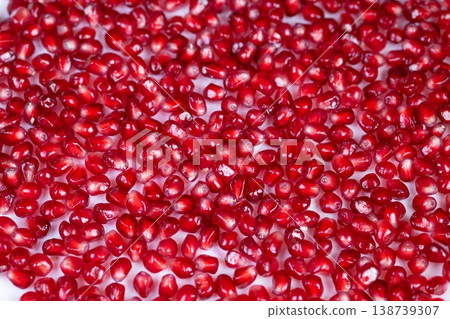 Minimal pomegranate seeds pattern with even spacing, vibrant ruby hues, subtle reflections, highkey composition, versatile for packaging, texture, or decorative design 138739307