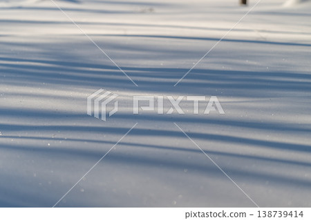 Chilly snow scenery with shadows. Frozen terrain featuring linear shadow patterns and icy textures. Vast winter tableau showcasing striped shading and smooth surface details Chilly snow scenery with shadows. Frozen terrain featuring linear shadow patterns and icy textures. Vast winter tableau showcasing striped shading and smooth surface details 138739414