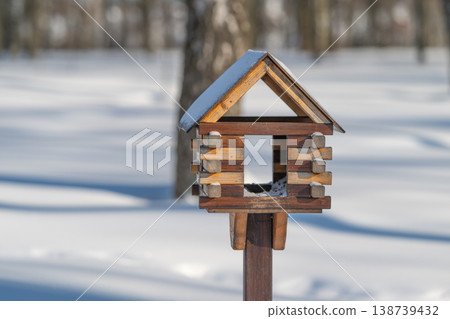 Wooden nesting box under birches. Handcrafted bird shelter amidst gentle birch shadows. Natural wooden birdhome positioned within peaceful backyard greenery scene Wooden nesting box under birches. Handcrafted bird shelter amidst gentle birch shadows. Natural wooden birdhome positioned within peaceful backyard greenery scene 138739432