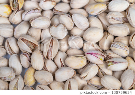 Pistachio motif with neutral tones. Repetitive arrangement of pistachio illustrations and natural shapes creating textured backgrounds for branding and packaging 138739634