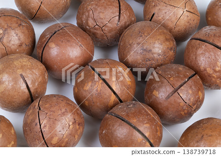 Cracked nuts for chocolate creation. Detailed view of nuts preparing for ganache. Closeup of cracked macadamia nuts arranged for ganache development with warm lighting 138739718