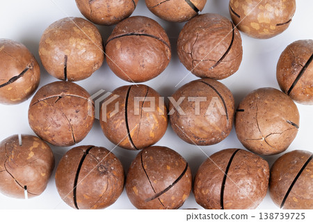 Studioshot macadamia nuts arranged on white backdrop, clean grid and consistent spacing highlight shell details and surface texture, modern feel for web banners and backgrounds 138739725