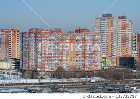 Urban brick apartments. Winter city highrise housing. Modern dense residential towers with balconies. Snowcovered grounds in vibrant cityscape with development prospects 138739797