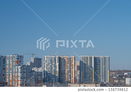 Contemporary city scene with housing. Urban residential area illuminated by winter sunlight. Vivid city environment showcasing modern homes and busy construction sites Contemporary city scene with housing. Urban residential area illuminated by winter sunlight. Vivid city environment showcasing modern homes and busy construction sites 138739812