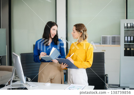 Business colleague business presents and explains and using laptop and tablet. Teamwork, financial Business colleague business presents and explains and using laptop and tablet. Teamwork, financial 138739856