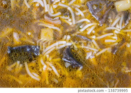 Rich broth with mushrooms and herbs. Creamy mushroom broth topped with herbs and noodles. Refined presentation of savory mushroom soup adorned with herbs and delicate noodles 138739995