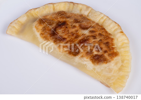 Gourmet cheburek on white backdrop, refined golden browning, detailed surface texture and crisp edge, crafted presentation potential for editorial and culinary features 138740017