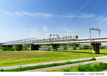 A view of the Keio Line railway bridge and trains from the Tamagawa River embankment in Kamifuda-cho, Chofu City, Tokyo. A view of the Keio Line railway bridge and trains from the Tamagawa River embankment in Kamifuda-cho, Chofu City, Tokyo. 138740369