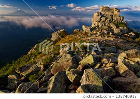 The Gojo-ishi rock formation on the summit of Mt. Kinpu in the morning, and Mt. Fuji above the clouds. The Gojo-ishi rock formation on the summit of Mt. Kinpu in the morning, and Mt. Fuji above the clouds. 138740912