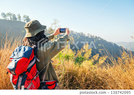 Golden hills stretch behind a hiker 138742095