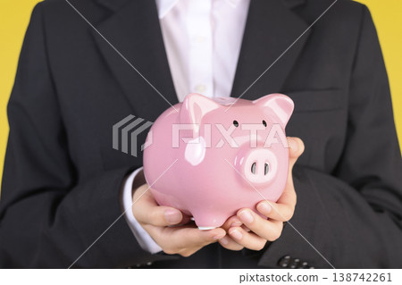 一位穿著西裝的女士拿著存錢罐 138742261