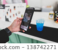 Close-up of a person scanning a QR code on a smartphone to pay for a drink at a cafe. Cashless transaction, mobile banking, and contactless payment technology in modern everyday lifestyle 138742271