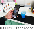 Close-up of a person scanning a QR code on a smartphone to pay for a drink at a cafe. Cashless transaction, mobile banking, and contactless payment technology in modern everyday lifestyle 138742272