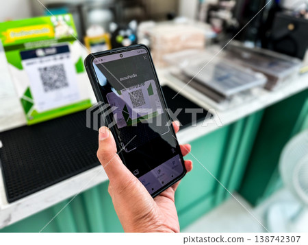 a person using a smartphone to scan a QR code for digital payment at a cafe counter. Modern cashless transaction, mobile banking, and contactless technology in everyday lifestyle a person using a smartphone to scan a QR code for digital payment at a cafe counter. Modern cashless transaction, mobile banking, and contactless technology in everyday lifestyle 138742307