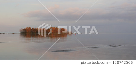 Bright orange colored trees on a smal island, Lake Vanern, Sweden. 138742566