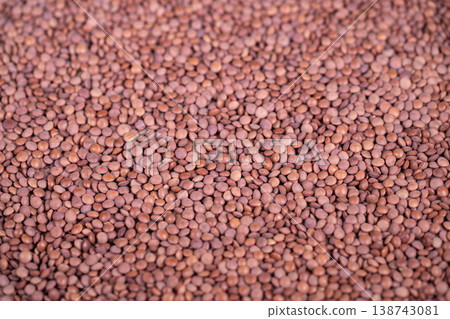 Close view of wholesome seeds. Detailed shot showcasing healthy seed texture. Macro photograph capturing rustic appeal of densely packed lentil seeds in natural tones 138743081