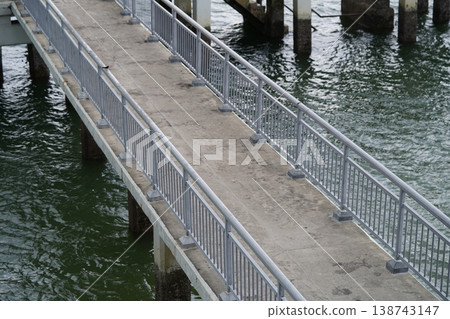 Elevated Walkway Over Water with Gray Metal Railings 138743147