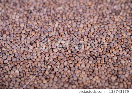 Bulk storage of natural lentil grains with wholesome ambiance. Heap of uniform brown lentil cereal perfect for storage and meal preparation with natural bright ambiance 138743179