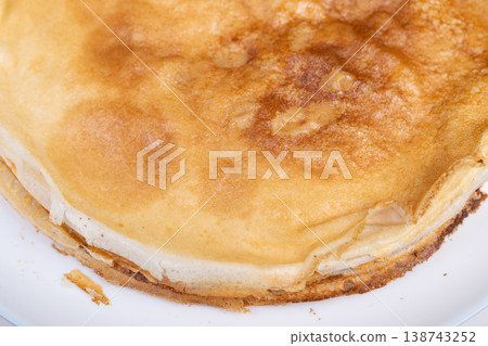 Homemade pancakes with golden edges create cheerful holiday atmosphere. Soft and buttery pancakes with crispy brown edges symbolize joyful Maslenitsa morning celebration 138743252