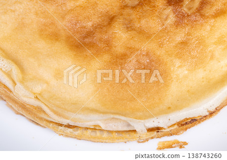 Sweet breakfast delight. Fluffy pancakes with gentle browning. Stack of golden crepes in warm morning glow. Warm light illuminates delicate layered pancakes on cozy plate 138743260