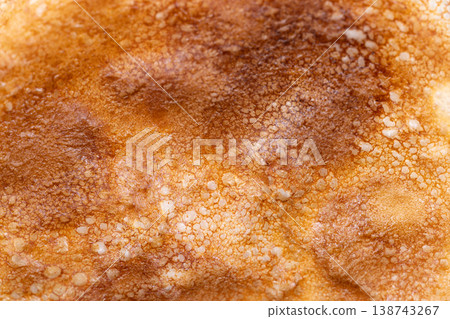 Golden pancake topped with caramelized sugar. Closeup of crunchy caramelized sugar on pancake surface. Rustic warmtoned image emphasizing caramelized sugar coating on pancake Golden pancake topped with caramelized sugar. Closeup of crunchy caramelized sugar on pancake surface. Rustic warmtoned image emphasizing caramelized sugar coating on pancake 138743267