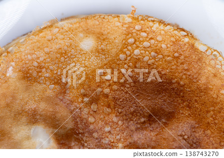 Delicious breakfast imagery. Zoomedin shot revealing textures and warm breakfast ambiance. Intimate perspective highlighting airy bubbles and crispy crust of morning pancake 138743270