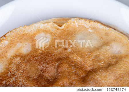 Image of golden pancake top. Visual representation of pancake with luminous golden crust. Snapshot capturing radiant and smooth surface of perfectly cooked pancake 138743274