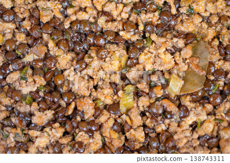 Close up cooked lentils with meat, crumbly mince, glossy brown lentils, diced onion, parsley flecks, warm steamy texture conveying rustic comfort and hearty home cooking Close up cooked lentils with meat, crumbly mince, glossy brown lentils, diced onion, parsley flecks, warm steamy texture conveying rustic comfort and hearty home cooking 138743311