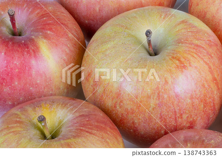 Fresh apple display. Close examination of mature apples with rustic countryside background. Intimate perspective capturing lush ripe apples with natural bloom and rustic texture 138743363