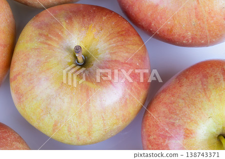 Closeup ripe greenred apples arranged in grid, natural variation in blush and russet, light dusting of orchard bloom, ideal for grocery shelf and vendor promotional imagery Closeup ripe greenred apples arranged in grid, natural variation in blush and russet, light dusting of orchard bloom, ideal for grocery shelf and vendor promotional imagery 138743371