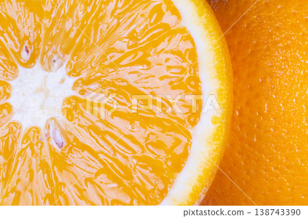 Closeup of zesty citrus with bartender in background. Detailed macro photograph highlighting vibrant orange garnish being prepared by bartender for drink advertisement Closeup of zesty citrus with bartender in background. Detailed macro photograph highlighting vibrant orange garnish being prepared by bartender for drink advertisement 138743390