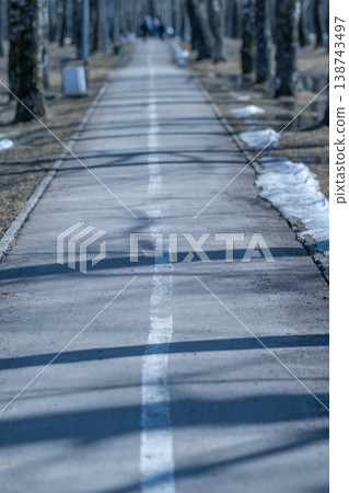 City route with snow shadows. Mountain bike trail featuring snowy streets and sunlight patterns. City street cycling lane decorated with snow and play of sunlight shadows City route with snow shadows. Mountain bike trail featuring snowy streets and sunlight patterns. City street cycling lane decorated with snow and play of sunlight shadows 138743497