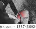 Close up monochrome photo of person hands holding painful knee with red glowing spot indicating severe joint pain, arthritis, sports injury, or inflammation in healthcare and medical concept. 138743692