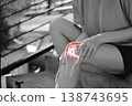 Monochrome photo of person holding painful knee with red glowing anatomical bone graphic overlay showing joint inflammation, sports injury, or severe arthritis in medical and healthcare concept. 138743695