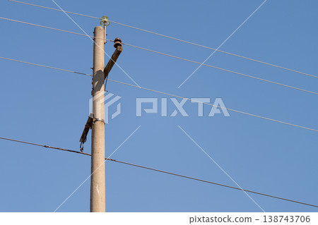 Tranquil rural utility pole with wires. Calm countryside scene featuring solitary power pole. Serene rural landscape showcasing isolated utility post with electrical lines Tranquil rural utility pole with wires. Calm countryside scene featuring solitary power pole. Serene rural landscape showcasing isolated utility post with electrical lines 138743706