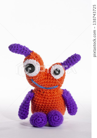 Knitted wool aliens in a glass on a white background Knitted wool aliens in a glass on a white background 138743725