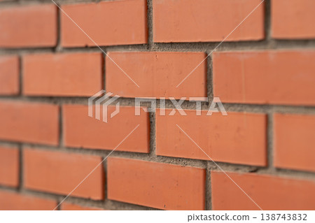 Uniform brick wall. Sleek red brick pattern for photography. Consistent red brick surface ideal for imagery. Evenly textured brick wall suitable for product and showcase displays 138743832