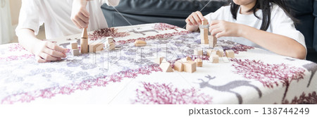 Children play with wooden blocks at a table in a calm home environment supporting creativity, learning, and early childhood development. Children play with wooden blocks at a table in a calm home environment supporting creativity, learning, and early childhood development. 138744249