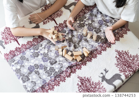 Children play with wooden blocks at a table in a calm home environment supporting creativity, learning, and early childhood development. Children play with wooden blocks at a table in a calm home environment supporting creativity, learning, and early childhood development. 138744253