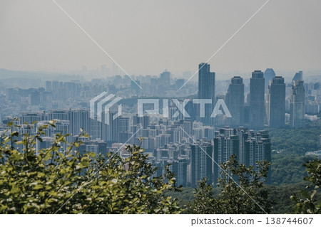Panoramic view of Seoul city skyline with high-rise buildings and mountains from Daemosan mountain peak. 138744607
