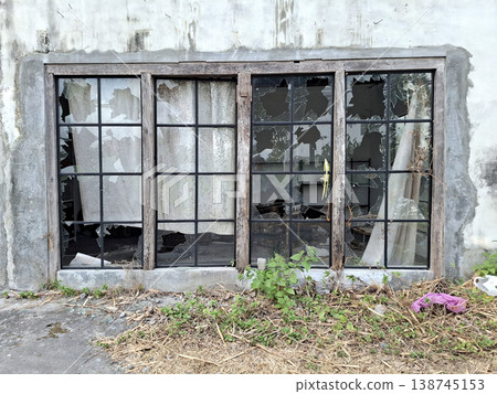 Abandoned Industrial Minimalist Scene with Broken Windows and Overgrown Vegetation Melancholic Abandoned Industrial Minimalist Scene with Broken Windows and Overgrown Vegetation Melancholic 138745153